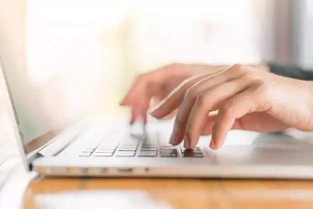Closeup of business woman hand typing on laptop keyboard
